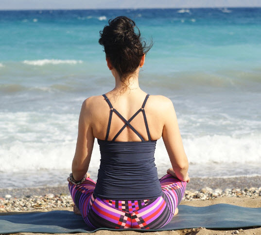 Woman practicing mindfulness-based cognitive therapy on the beach