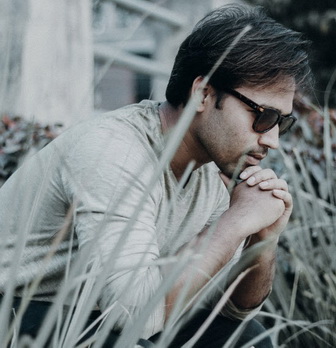 Man with OCD disorder sitting on the steps looking worried