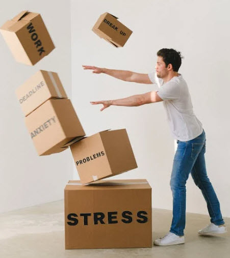 Man knocking over boxes depicting being affected by stress related issues