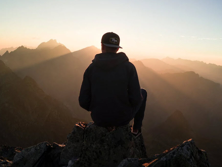 Trauma reduction mental health patient sitting on the top of a mountain